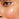An extreme close-up of a person's mid-face, focusing on the cheek and the area under the eye. The skin has a hydrated, dewy finish, with a prominent, localized patch of pink flushing and mild irritation across the center of the cheek.