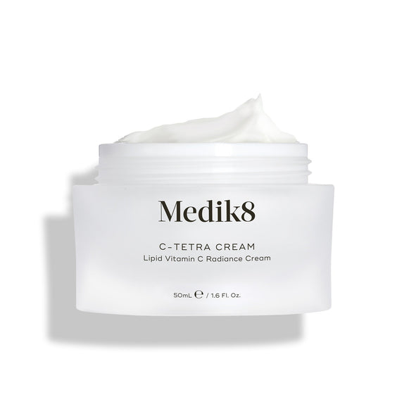 Medik8 C-Tetra Cream jar displayed open against a clean white background with soft shadows. The white, frosted-glass jar features the Medik8 logo and is labeled  C-TETRA CREAM Lipid Vitamin C Radiance Cream  in a 50mL size. A thick swirl of white cream is visible on top of the jar, highlighting its moisturising texture.-41