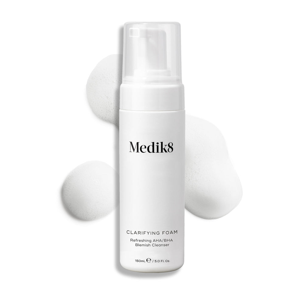 Medik8 Clarifying Foam pump bottle displayed on a clean white background with three dollops of white airy foam. Text identifies it as a Refreshing AHA/BHA Blemish Cleanser in a 150mL size.
