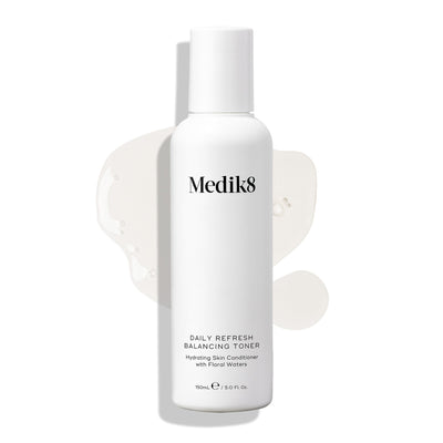 Medik8 Daily Refresh Balancing Toner bottle stands on a white background with a clear liquid spill. Text identifies it as a  Hydrating Skin Conditioner with Floral Waters  in a 150mL size.