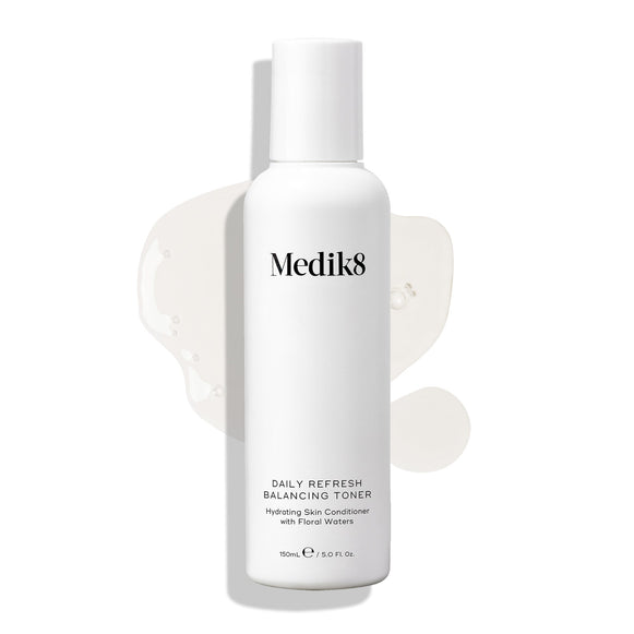 Medik8 Daily Refresh Balancing Toner bottle stands on a white background with a clear liquid spill. Text identifies it as a  Hydrating Skin Conditioner with Floral Waters  in a 150mL size.-45