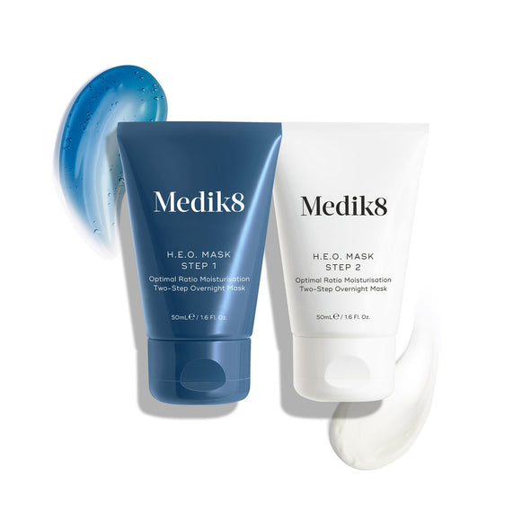 The two tubes of Medik8 H.E.O. Mask are displayed: a blue tube for Step 1 with a blue gel swatch, and a white tube for Step 2 with a white cream swatch.-6
