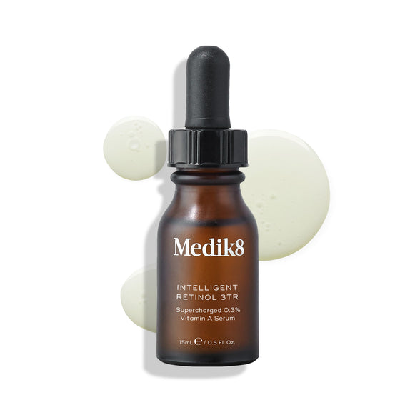 Medik8 Intelligent Retinol 3TR serum bottle stands against a clean white background with three clear liquid droplets. Text identifies the product as a 15mL  Supercharged 0.3% Vitamin A Serum. -28