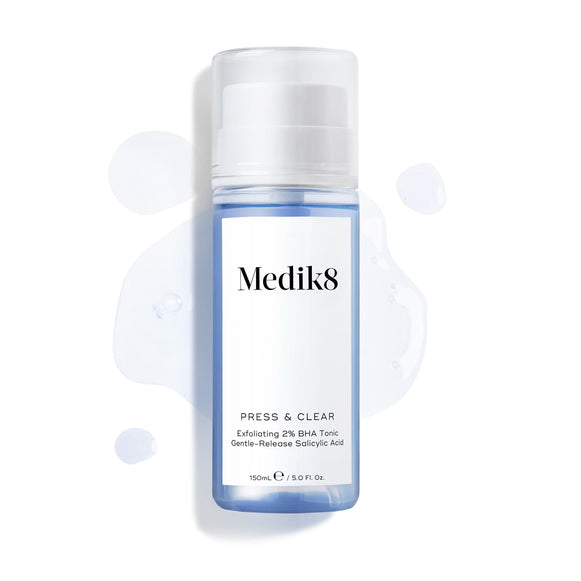 Medik8 Press & Clear bottle (150ml) displayed on a white background with splashes of blue tonic around it. Text highlights the  Exfoliating 2% BHA Tonic  formula.-20