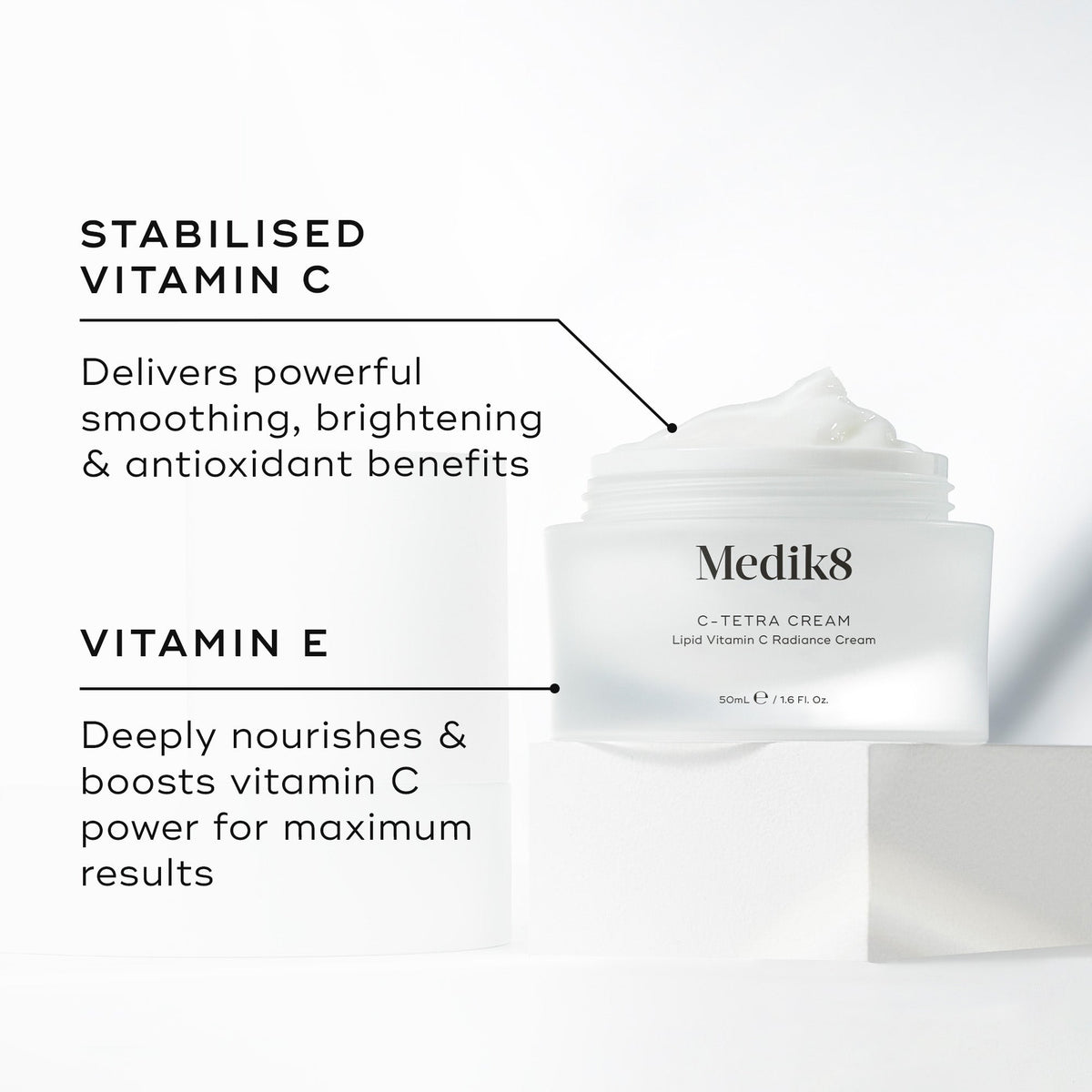 "Medik8 C-Tetra Cream jar displayed open on a white stone block against a clean white background. The image features two key ingredients and their benefits:

STABILISED VITAMIN C: Delivers powerful smoothing, brightening, and antioxidant benefits.

VITAMIN E: Deeply nourishes and boosts vitamin C power for maximum results."