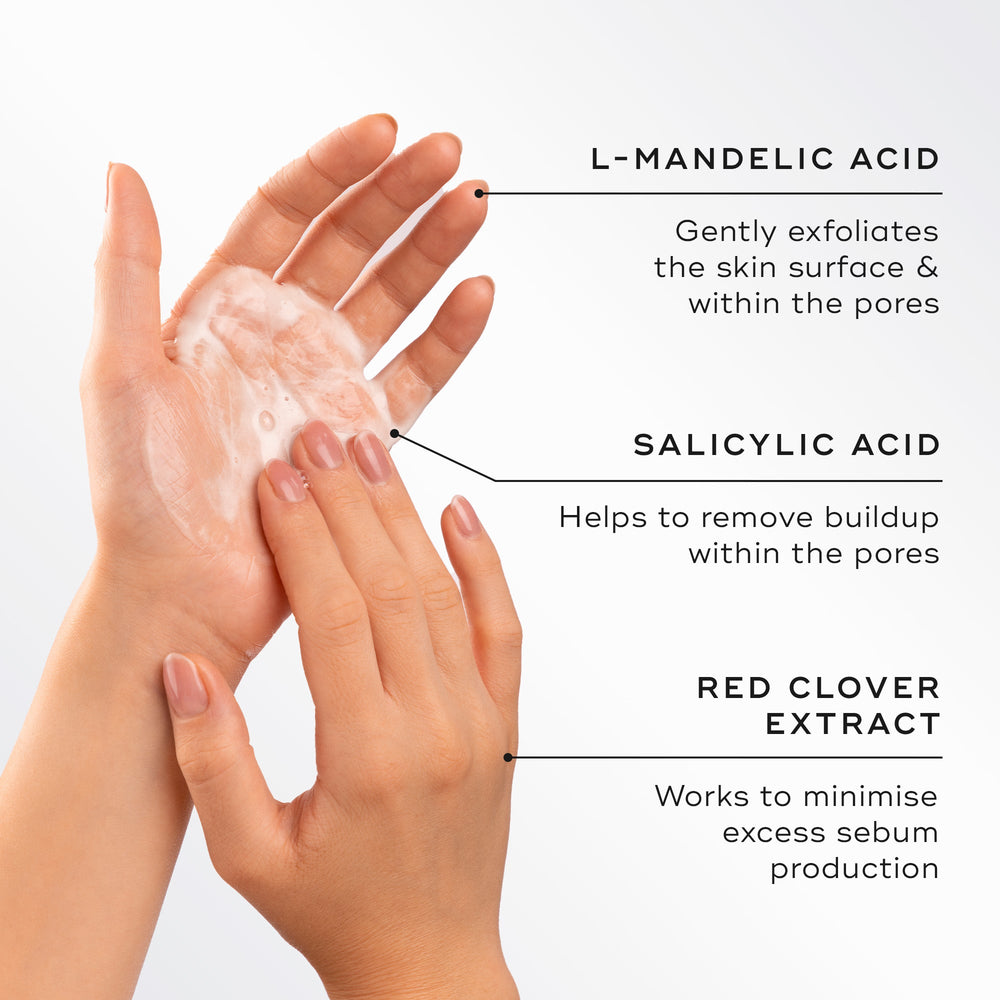 Two hands lather the cleanser into a foam next to text detailing key ingredients. Highlights include L-Mandelic Acid to exfoliate, Salicylic Acid to remove buildup, and Red Clover Extract to minimize excess sebum.