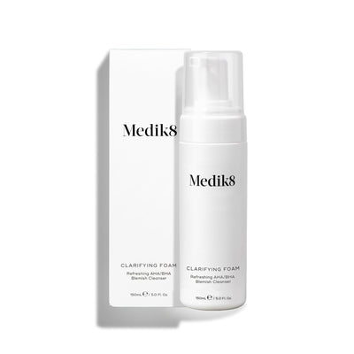 Medik8 Clarifying Foam pump bottle stands next to its matching white outer carton on a clean white background. Text on both identifies the product as a 150mL Refreshing AHA/BHA Blemish Cleanser.