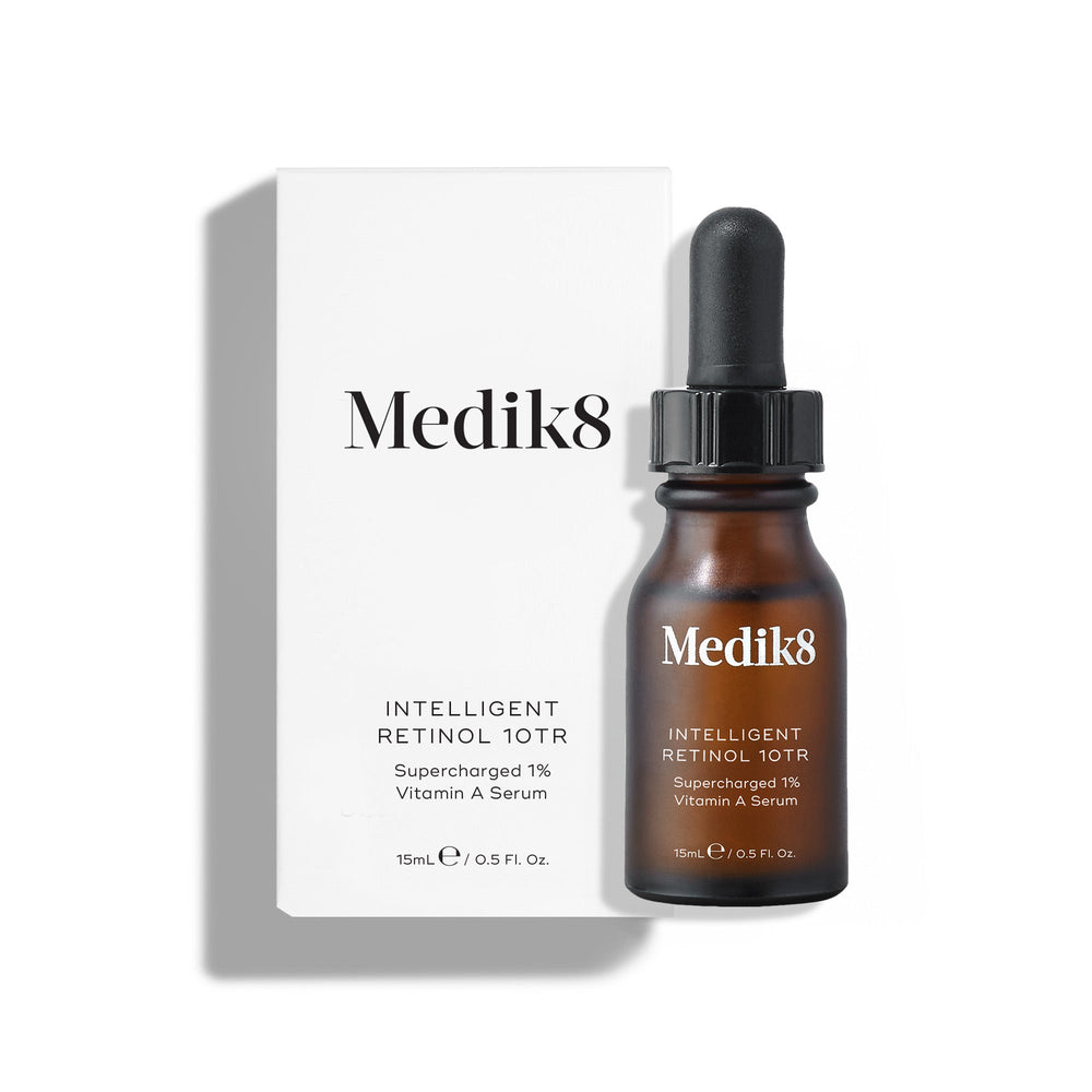 Medik8 Intelligent Retinol 10TR serum bottle stands in front of its matching white product carton on a clean white background. Text identifies the product as a 15mL  Supercharged 10% Vitamin A Serum. 