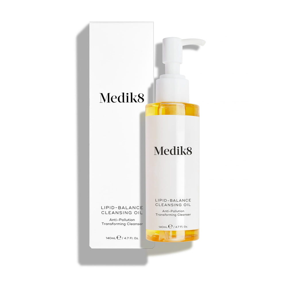 Medik8 Lipid-Balance Cleansing Oil bottle stands next to its white packaging carton. Text highlights the  Anti-Pollution Transforming Cleanser  formula and 140mL size.