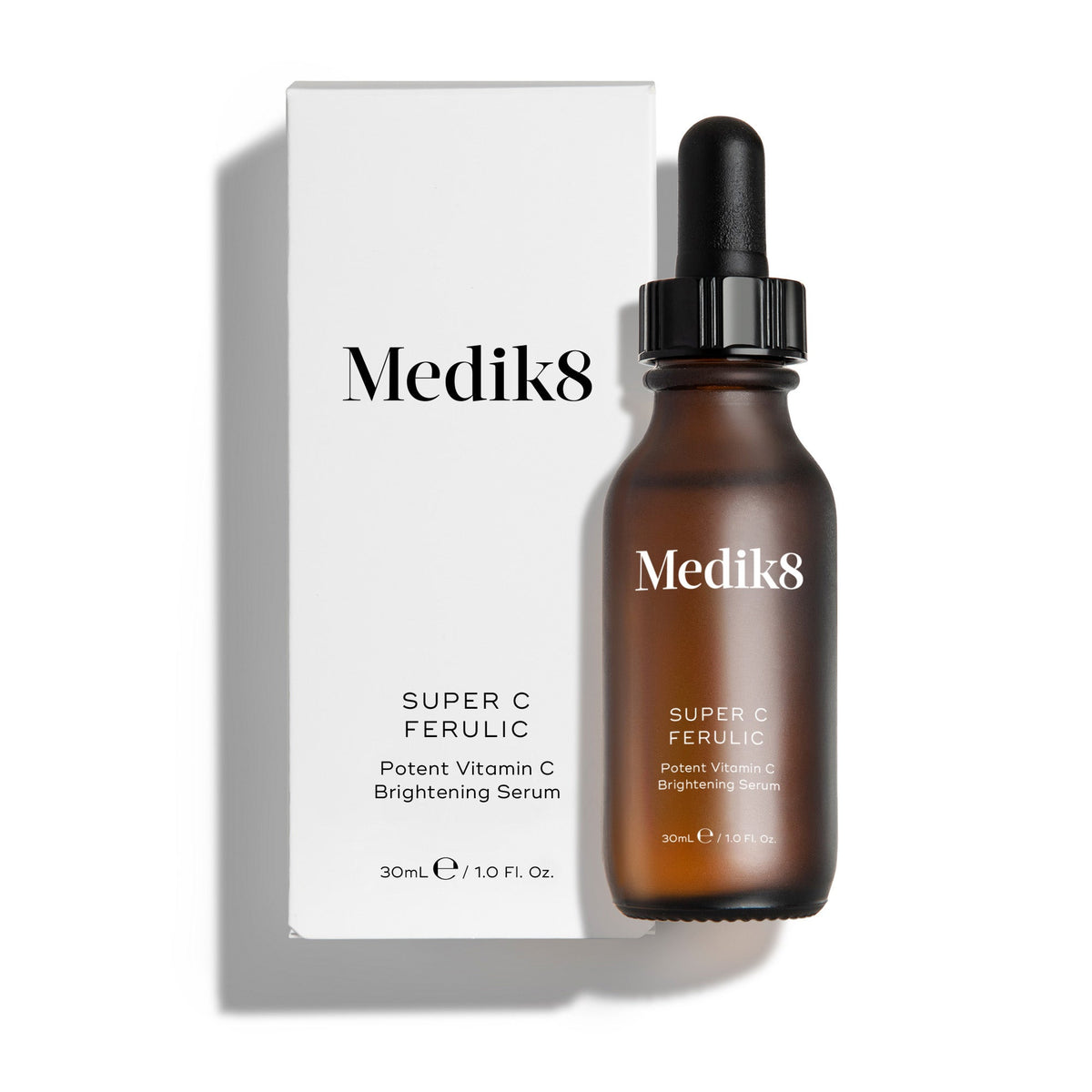 Medik8 Super C Ferulic serum bottle and its white cardboard carton displayed on a clean white background with soft shadows. The amber glass bottle with a black dropper cap and the matching white box both feature the Medik8 logo and identify the product as  SUPER C FERULIC Potent Vitamin C Brightening Serum  in a 30mL size.