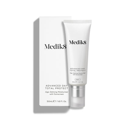 Medik8 Advanced Day Total Protect tube stands on a clean white background with a matching white outer carton. Text identifies the product as a 50mL Age-Defying Moisturiser with SPF 30 and 5* UVA protection.