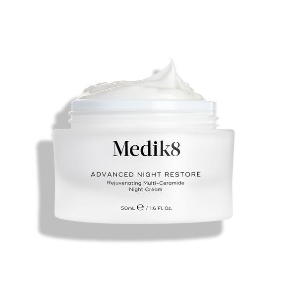 Medik8 Advanced Night Restore cream jar shown open with a rich dollop of white cream peaked on top against a clean white background, highlighting its smooth, restorative texture. Black text on the jar reads  Rejuvenating Multi-Ceramide Night Cream .-3