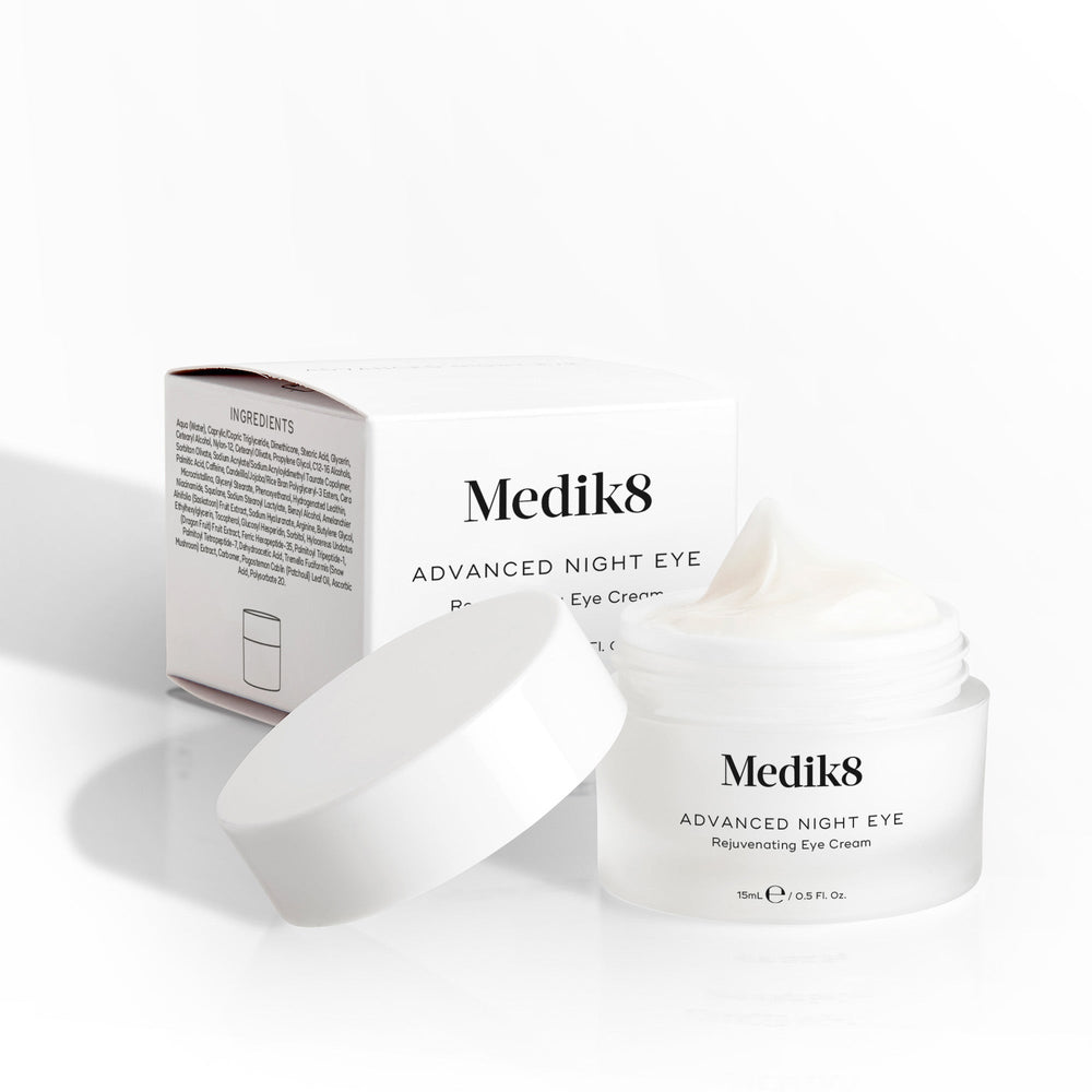 Medik8 Advanced Night Eye cream jar sits open next to its packaging box on a white background. Text highlights the  Rejuvenating Eye Cream  formula and 15mL size.