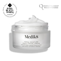 An open frosted glass jar of Medik8 Total Moisture Daily Facial Cream with a peak of white cream on top, set against a clean white background. Badges in the top corners indicate it is a "Daisy Beauty Awards Vinnare 2025" (Winner) and "Dermatologist Recommended."