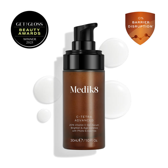 Medik8 C-Tetra Advanced bottle displayed on a clean white background with translucent serum droplets, highlighting its lightweight gel-serum texture.-5