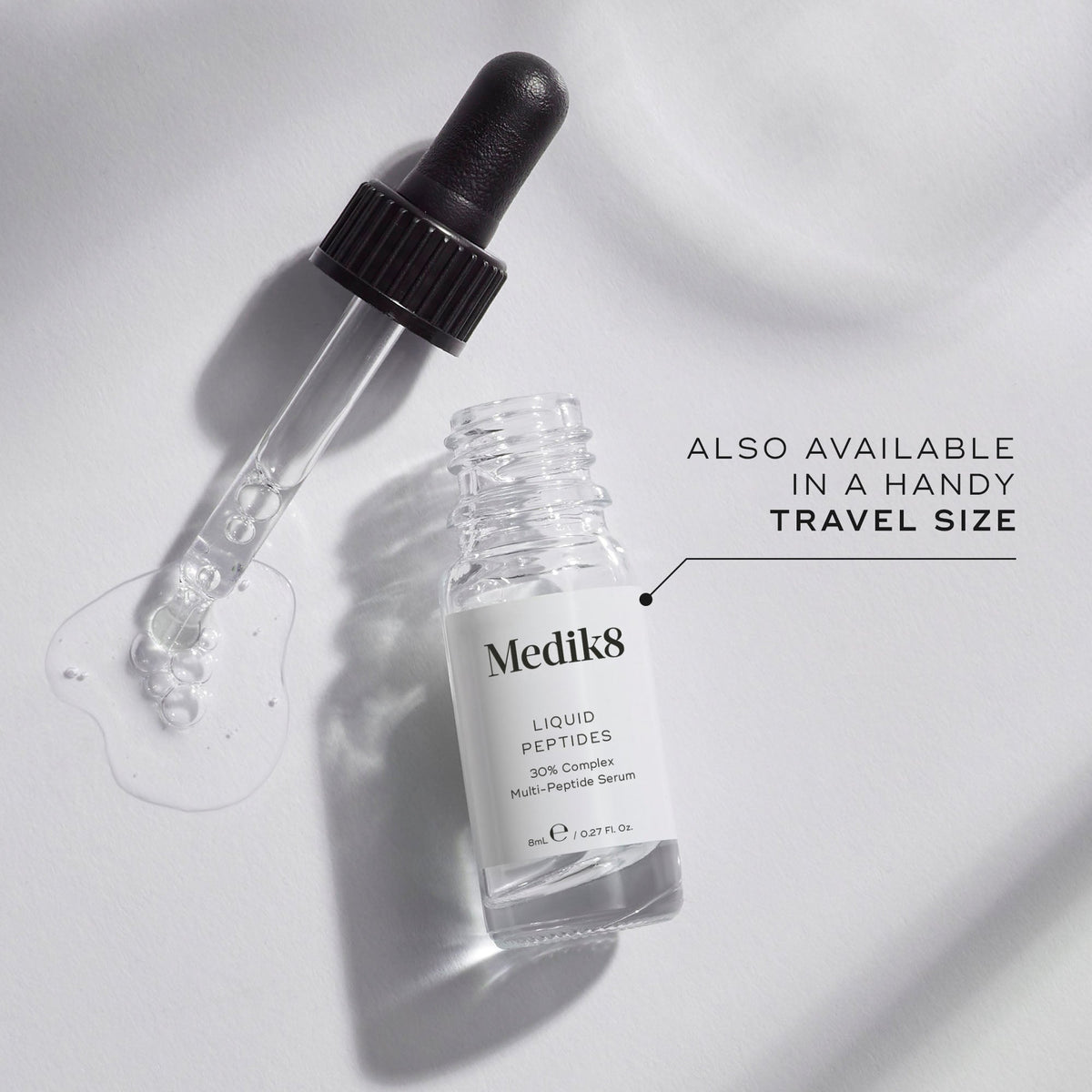 A small clear glass bottle (8mL) of Medik8 Liquid Peptides serum, with its dropper resting beside it. Text indicates it's  ALSO AVAILABLE IN A HANDY TRAVEL SIZE.