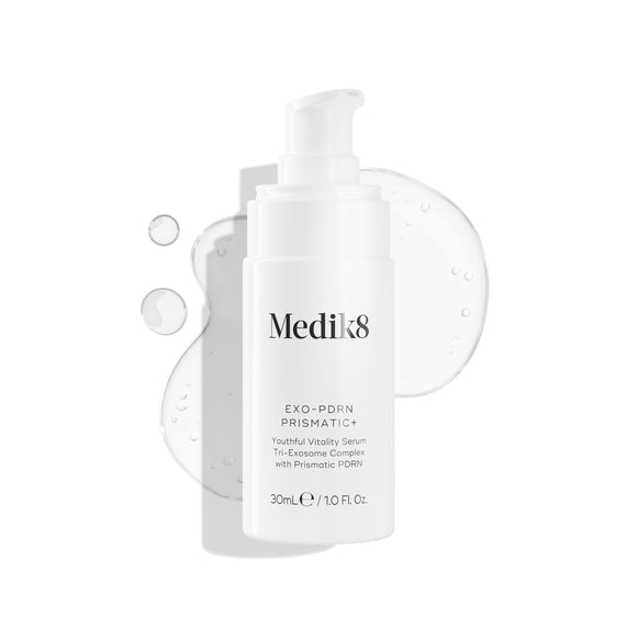 A white pump bottle of Medik8 EXO-PDRN Prismatic+ Youthful Vitality Serum rests on a white background, surrounded by a clear, glossy smear of the serum texture.-2
