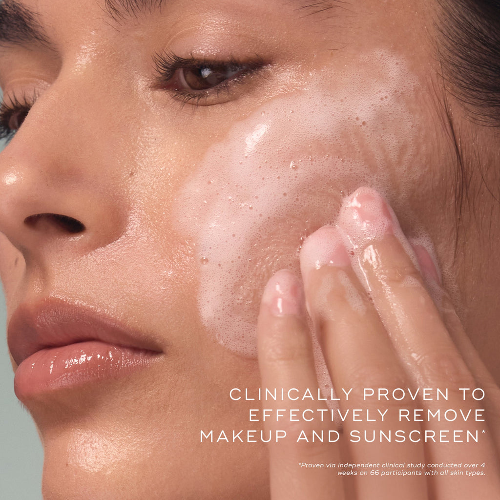 Close-up of a woman cleansing her face with a foaming gel, demonstrating product texture and application with supporting claim text