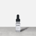 Medik8 Hydr8 B5 travel-sized serum bottle stand on a grey textured surface against a neutral background. Text on the 8mL bottle identifies it as a "Liquid Rehydration Serum.