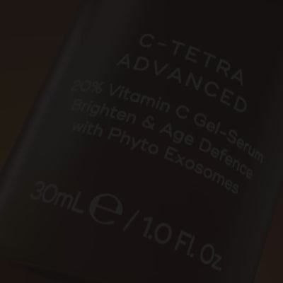 A video for Medik8 C-Tetra Advanced opens with a close-up of the bottle's label, then shows a woman applying the product to her cheek. A split-screen before-and-after image of a woman's cheek demonstrates how the product can "VISIBLY BRIGHTEN SKIN & REDUCE WRINKLES" after 4 weeks. The video then highlights key ingredients: "20% VITAMIN C" and "PHYTO EXOSOMES" with "0% DISRUPTION TO SKIN BARRIER*". It concludes with a shot of the product alongside the Medik8 logo and a "Certified B Corporation" badge.
